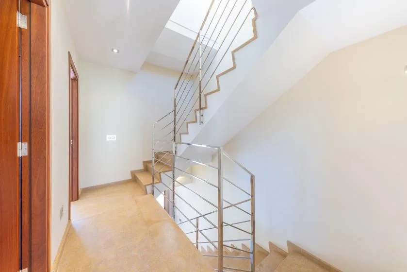 A bright stairwell with pale walls and metal railings.