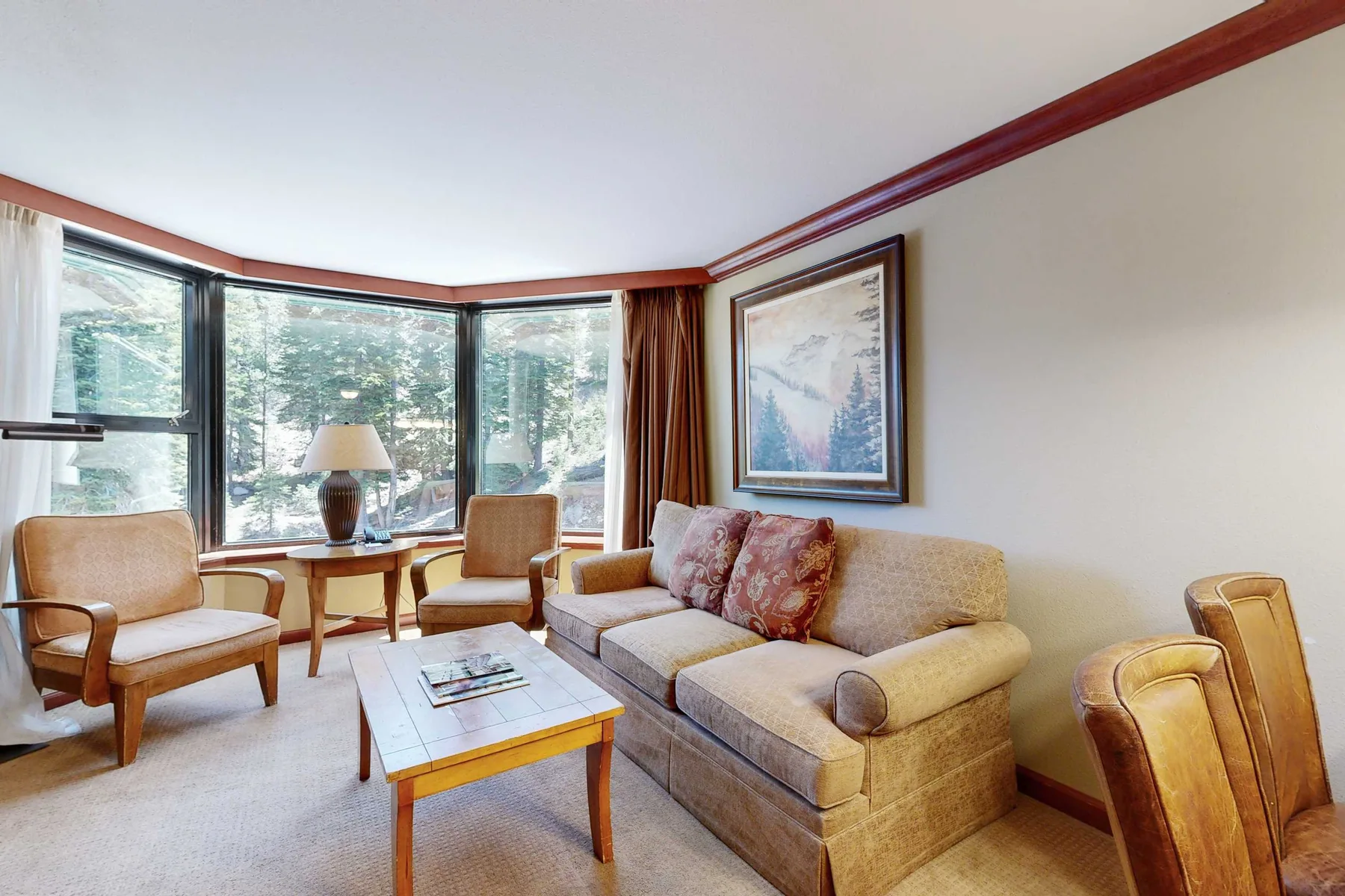 Una sala de estar con asientos junto a grandes ventanas.