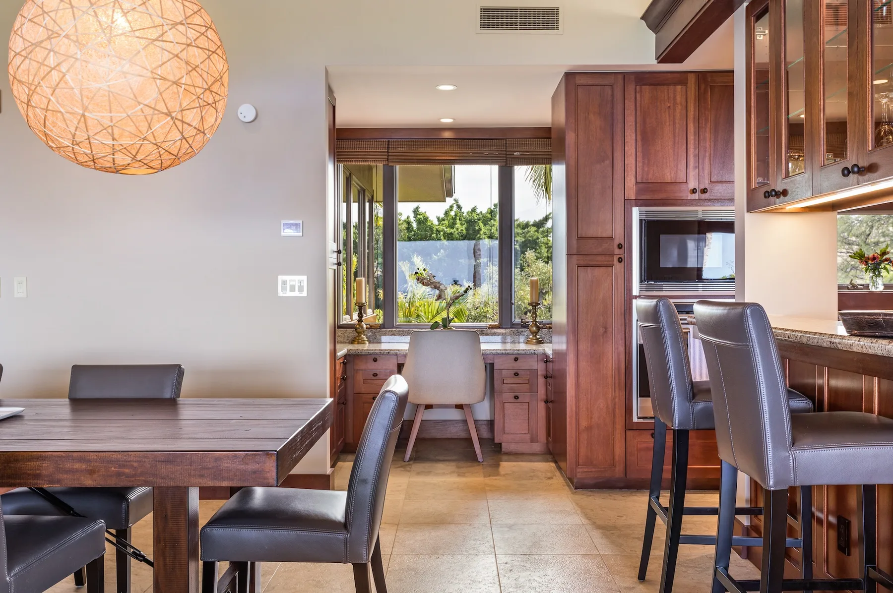 Un comedor con una mesa de madera, asientos y una barra de cocina.