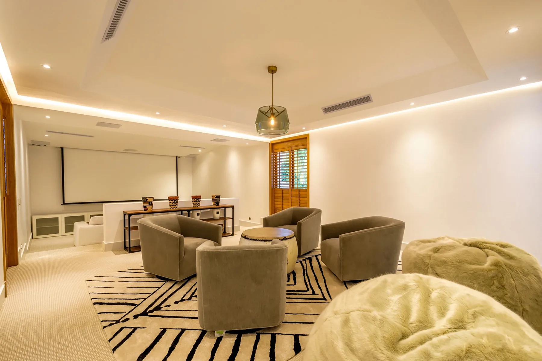 Una sala amplia con asientos alrededor de una mesa baja sobre una alfombra estampada.
