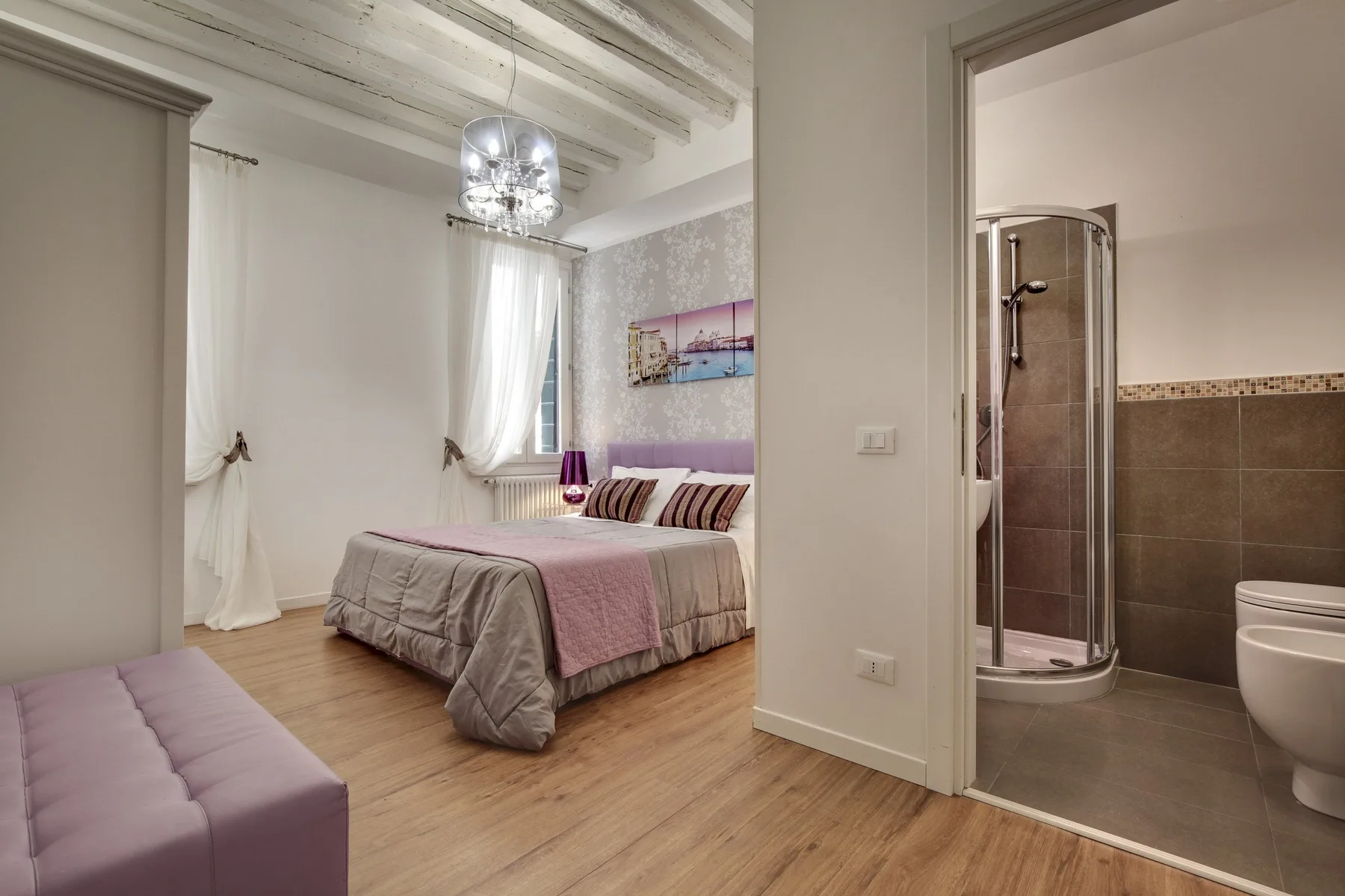 Un dormitorio con una cama y un baño visible a través de la puerta abierta.