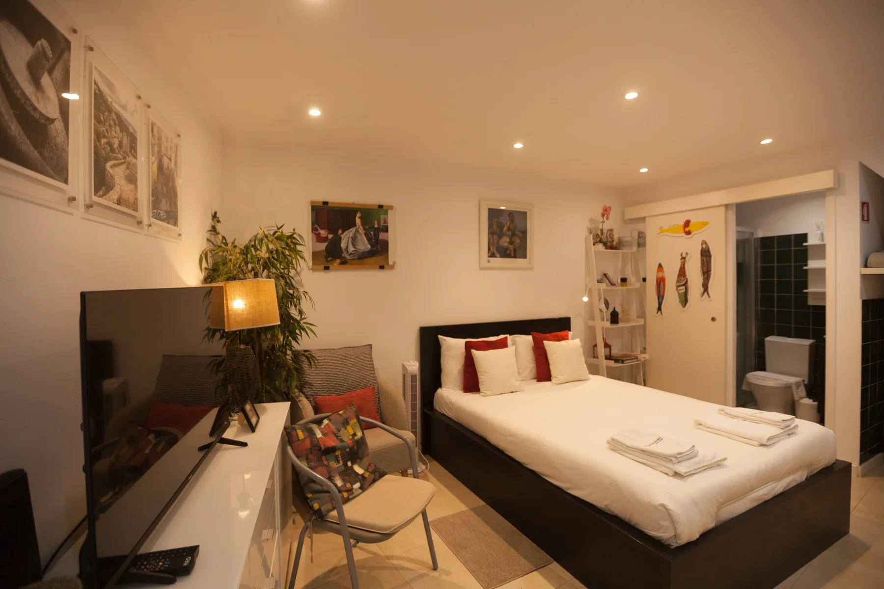A bedroom with a large bed, television, and seating area.