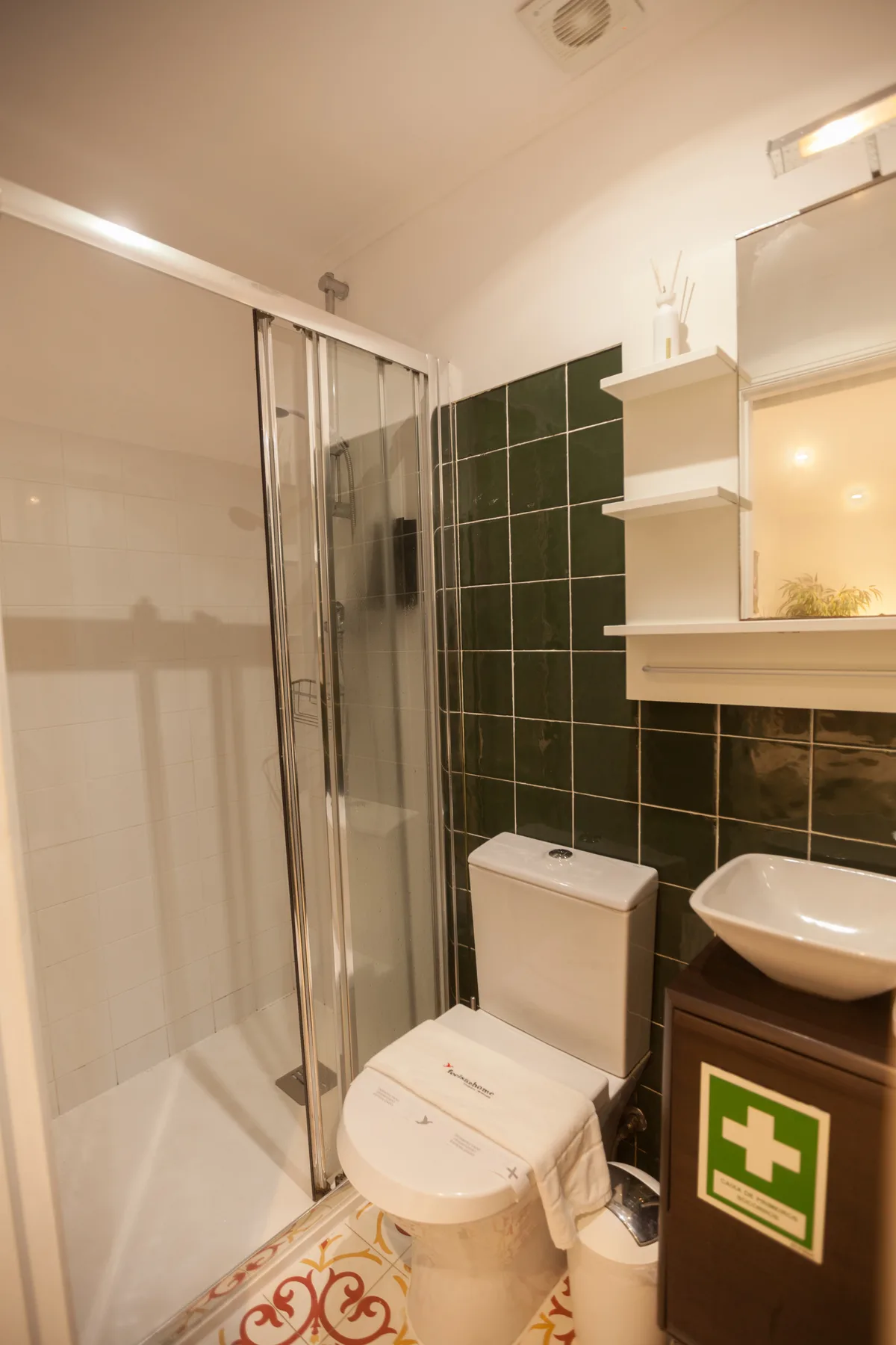 A bathroom with a glass shower, toilet, and sink.