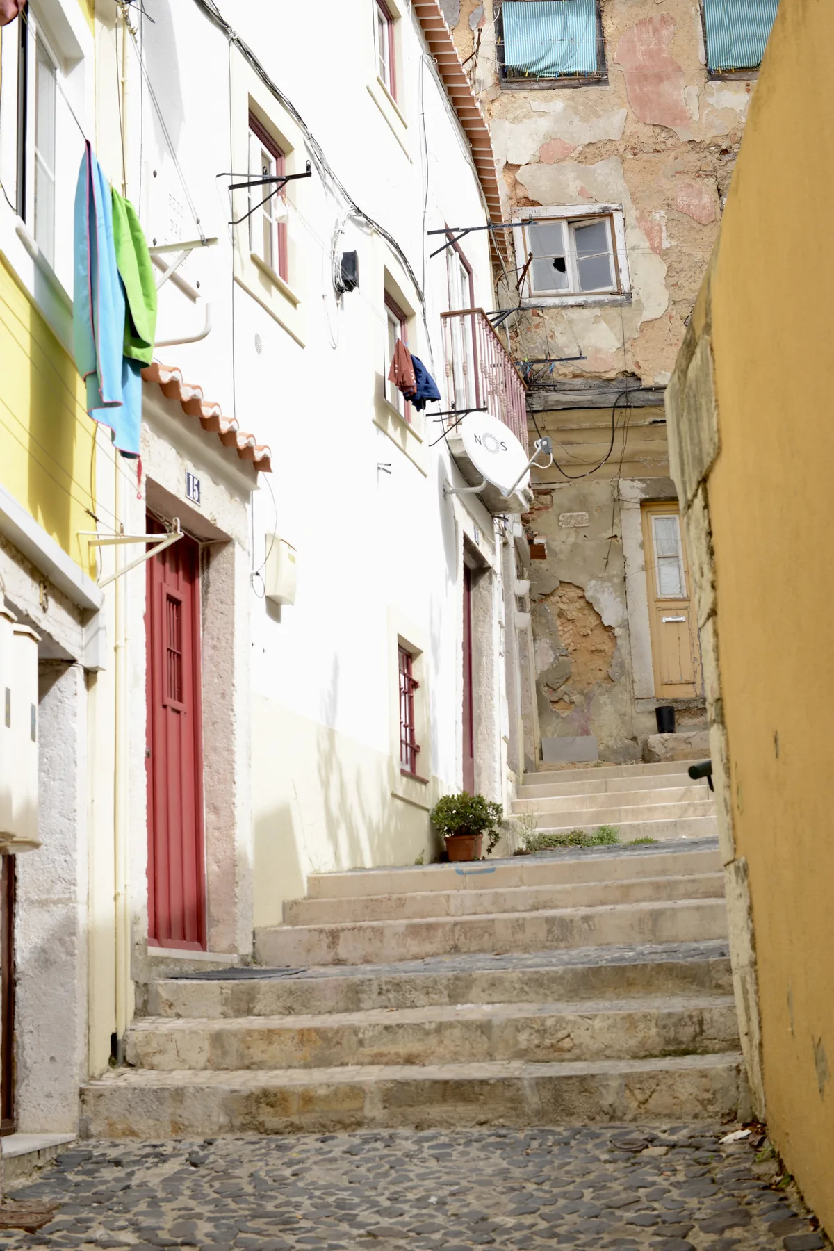 A narrow stone stairway climbs between closely spaced buildings.