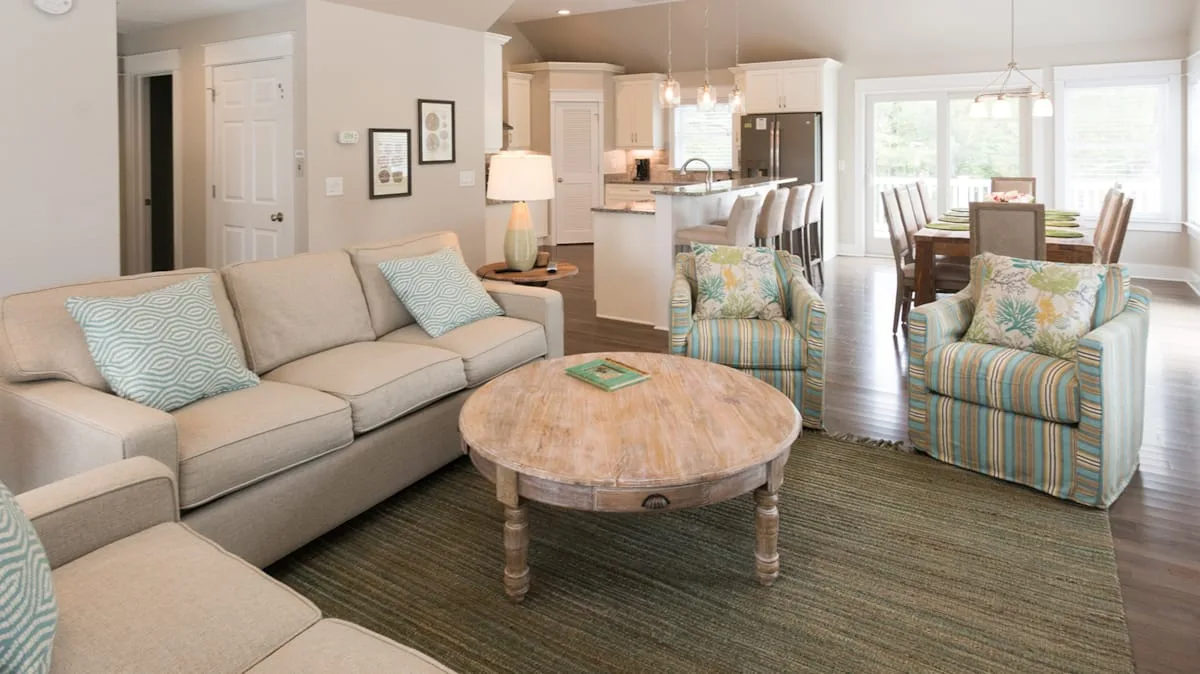 A bright living room with a sectional sofa and a round coffee table.
