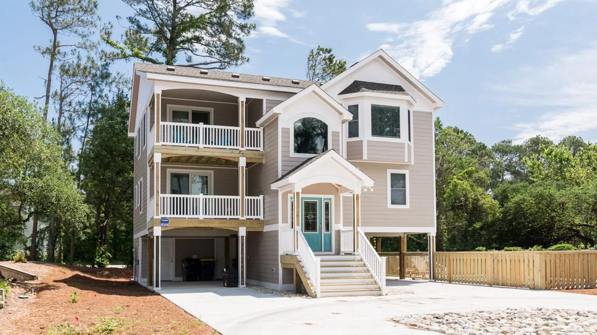 A large multi-level house with balconies and a broad front staircase.