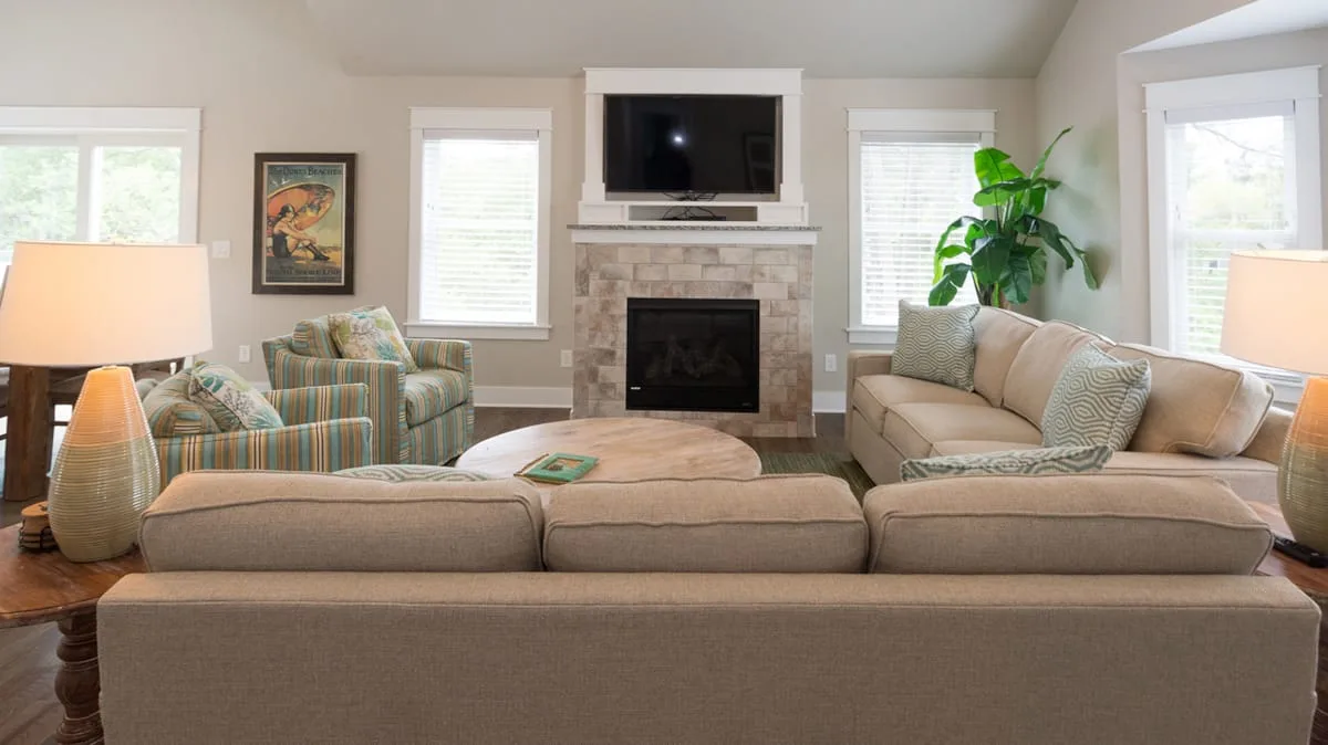 A living room with comfortable seating arranged around a fireplace.
