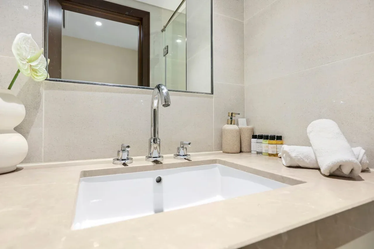 A bathroom vanity with a built-in sink, mirror, and neatly folded towels.