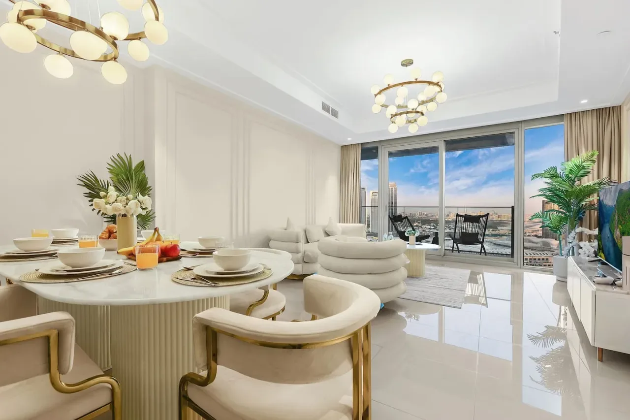 Bright living and dining area with seating beside large windows.