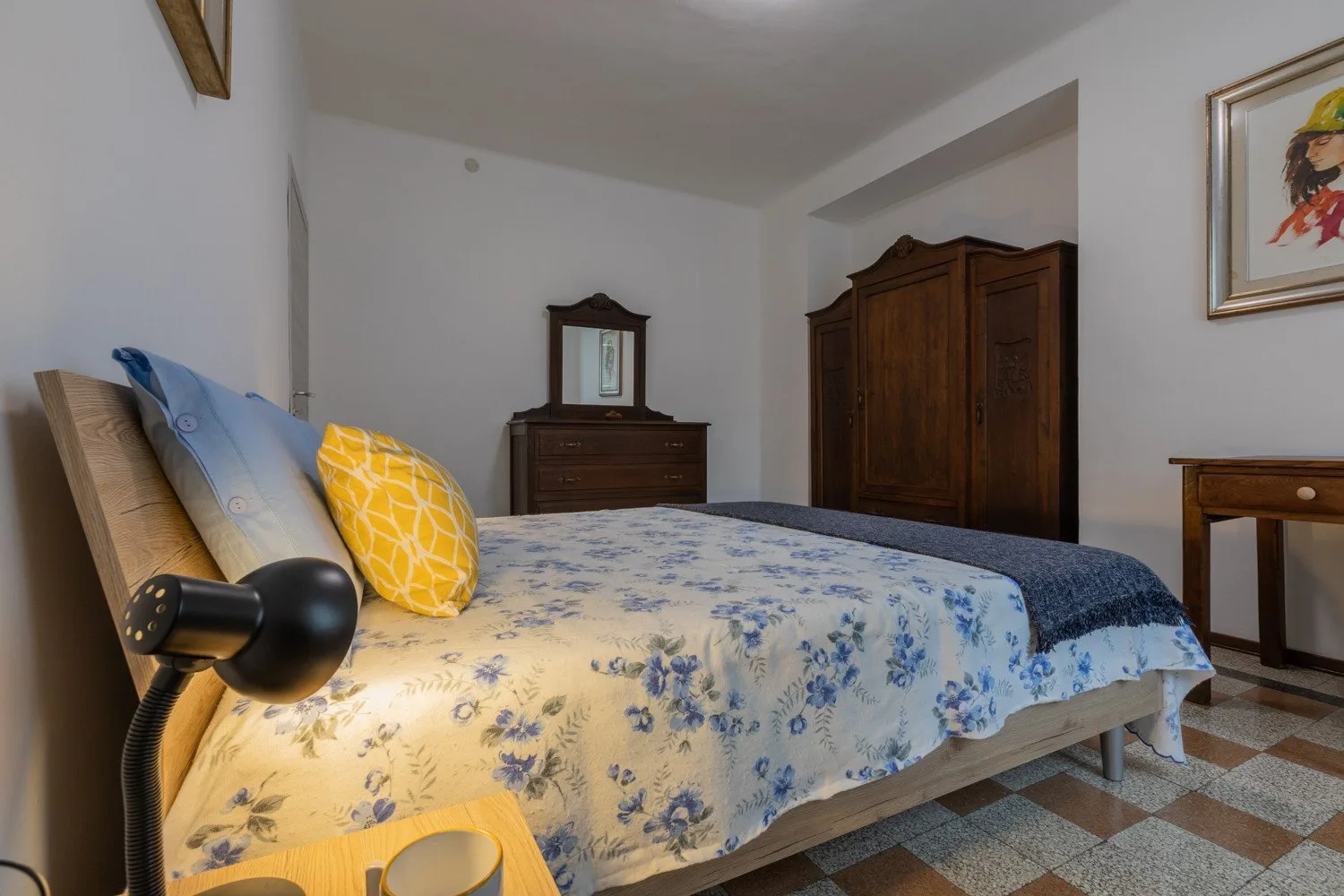 Un dormitorio con una colcha floral y armarios de madera.
