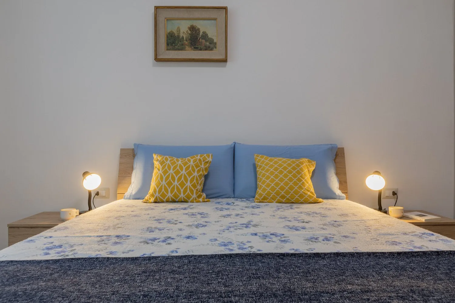 Un dormitorio con una cama vestida con ropa de cama azul y amarilla.