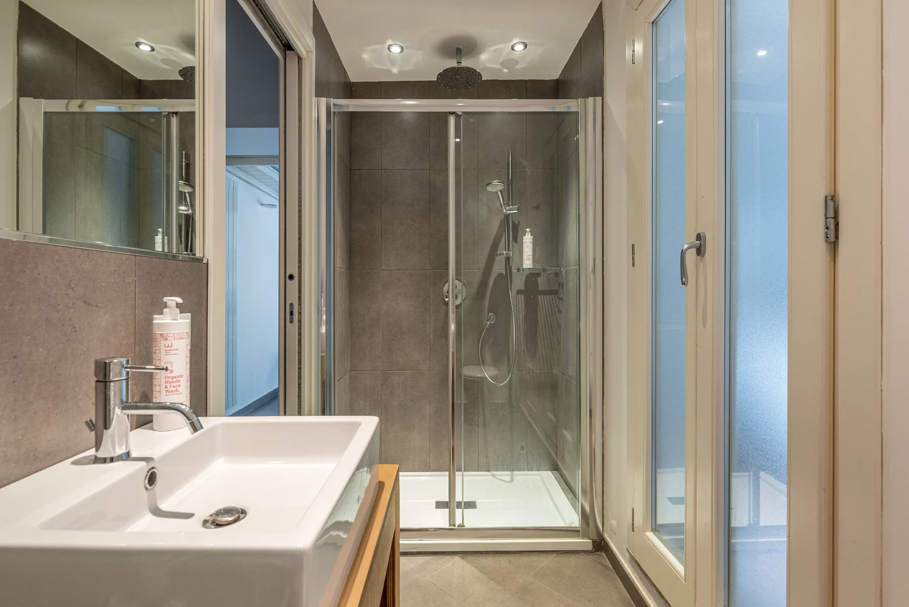 Un baño con lavabo y ducha de cristal.