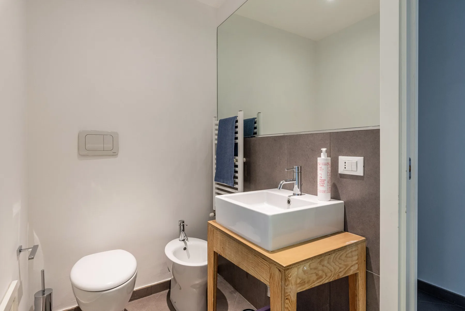 Un baño con un lavabo sobre una encimera de madera y un inodoro.