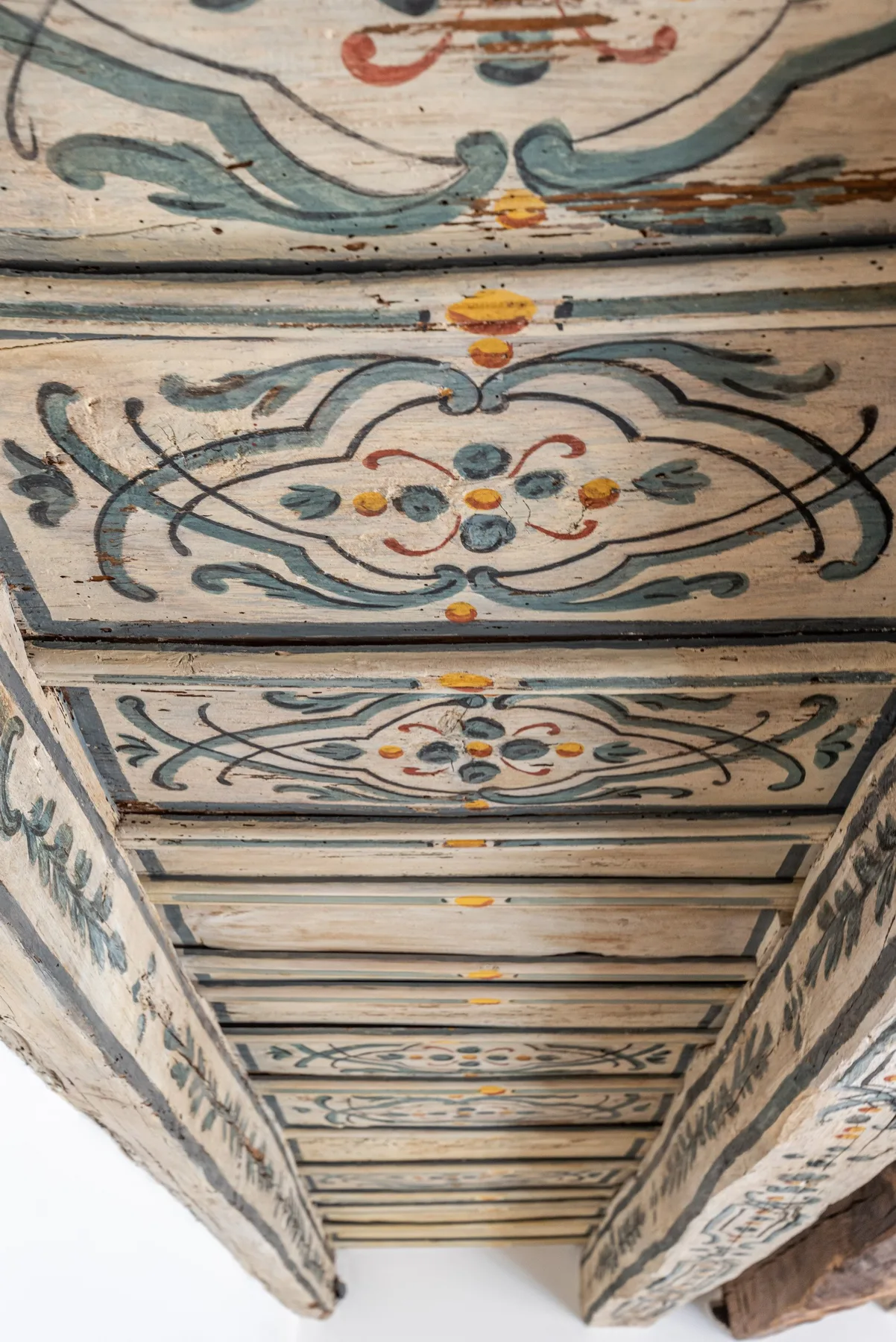 Un techo pintado con motivos florales curvos y detalles de colores.