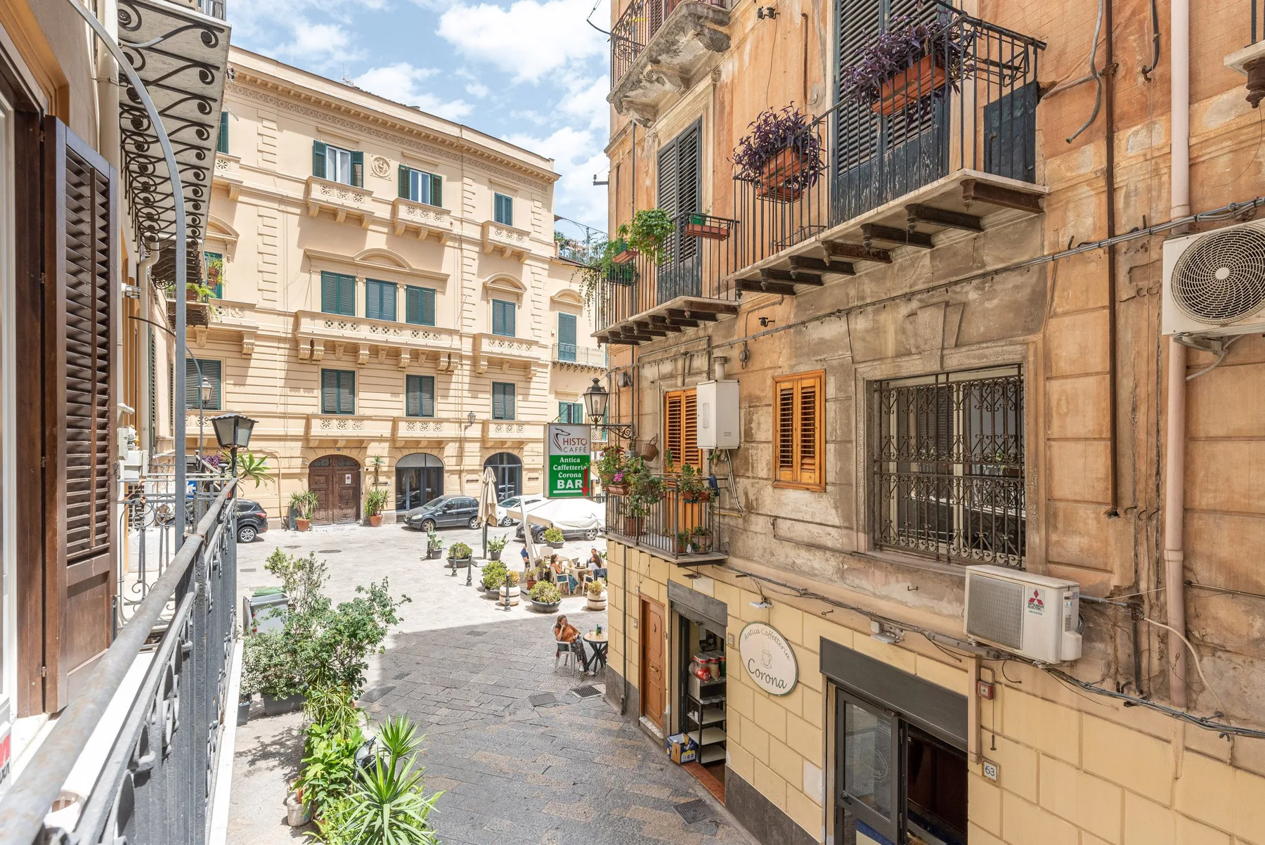 Una calle estrecha de la ciudad bordeada de edificios históricos y balcones.