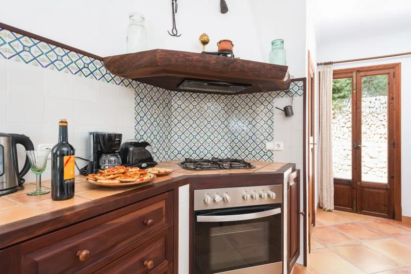 Una cocina con azulejos, encimera, placa de cocina y horno.