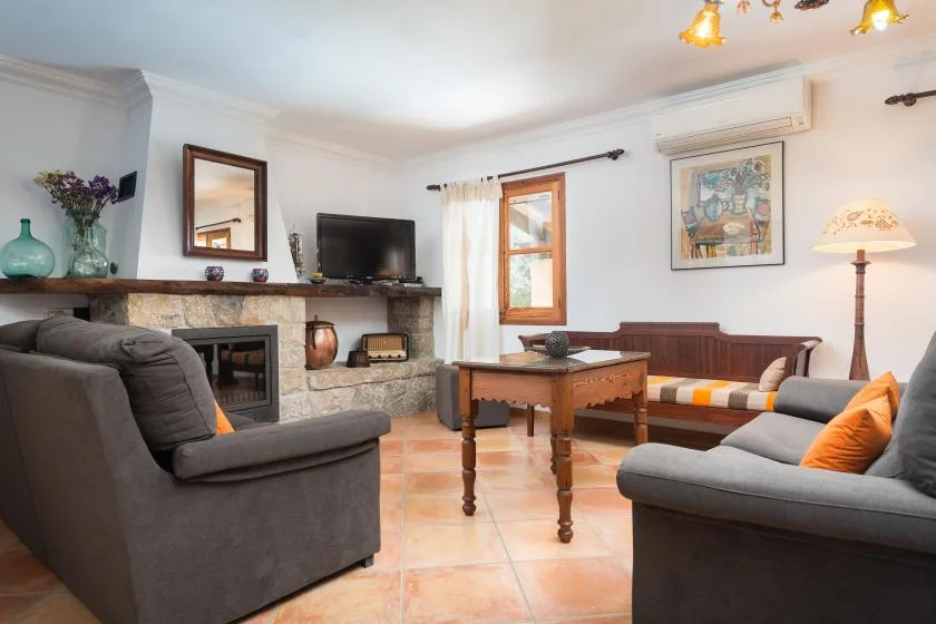 Una sala de estar con asientos alrededor de una mesa de centro de madera y una chimenea.