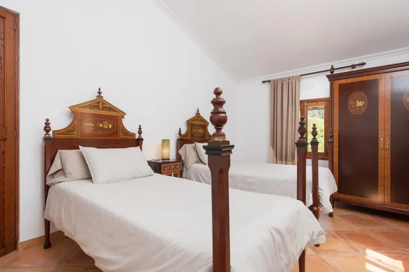 Un dormitorio con dos camas y un gran armario de madera.