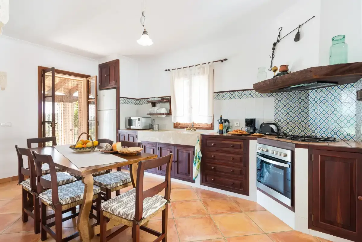 Una cocina luminosa con mesa de comedor y muebles de madera.
