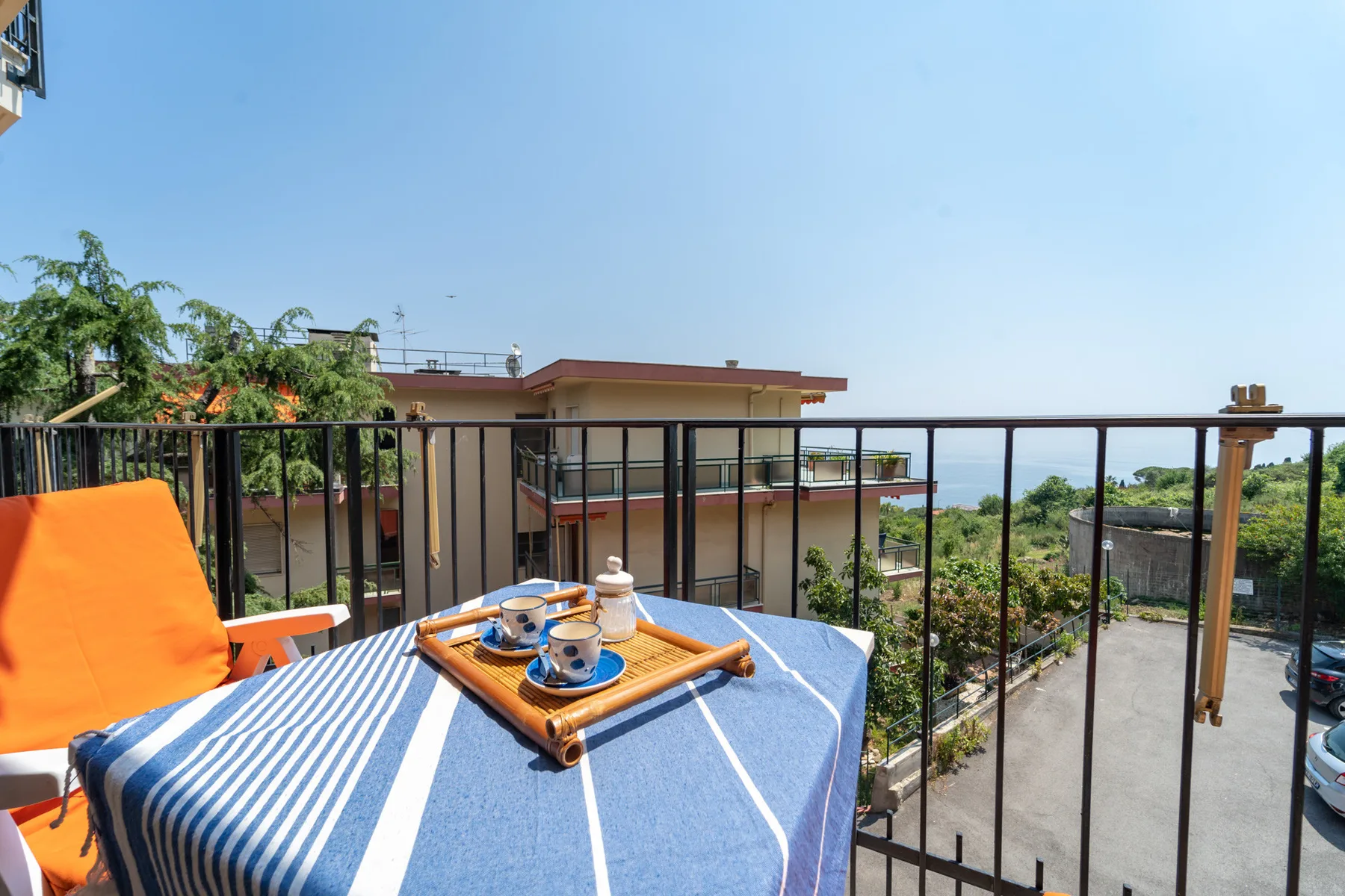 A rooftop terrace has a striped tablecloth and a tray set on the table.