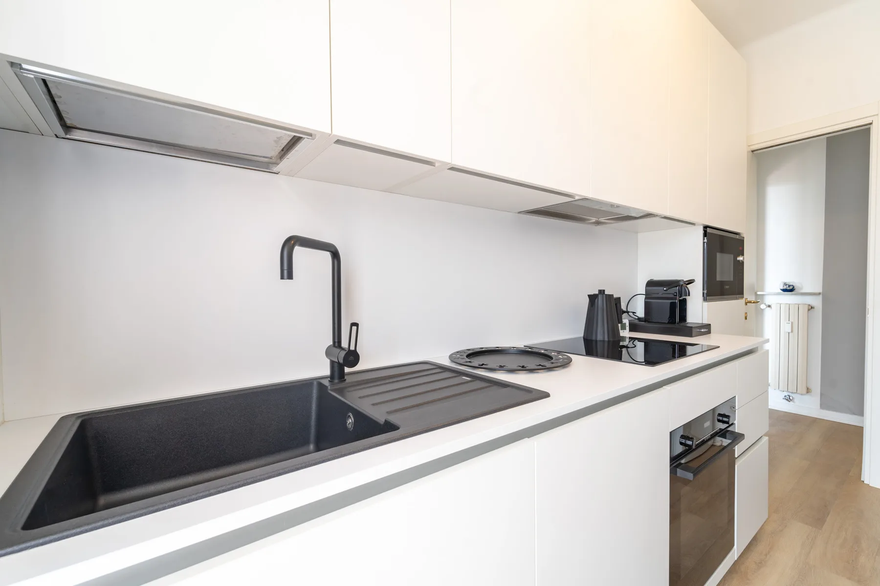 A modern kitchen with a sink, cooktop, and built-in oven.