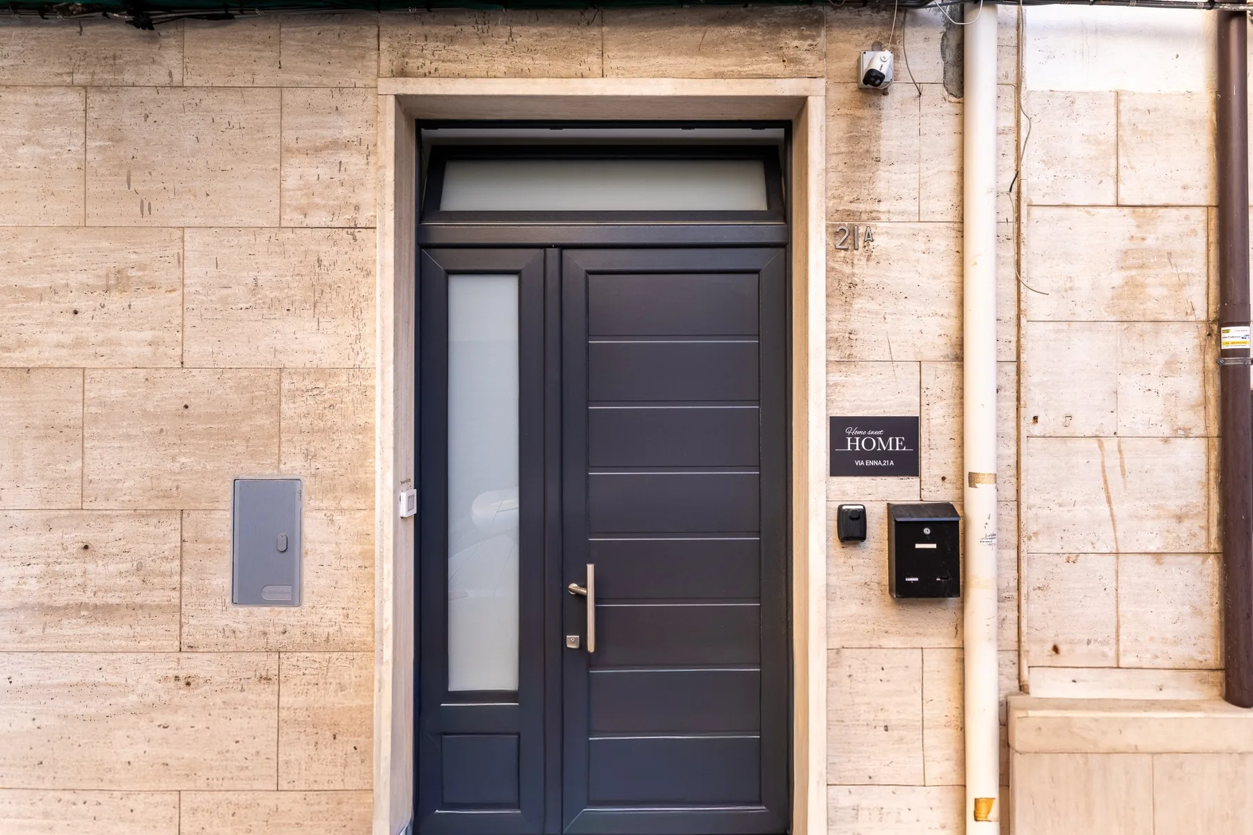 A dark entrance door is set into a pale stone facade.