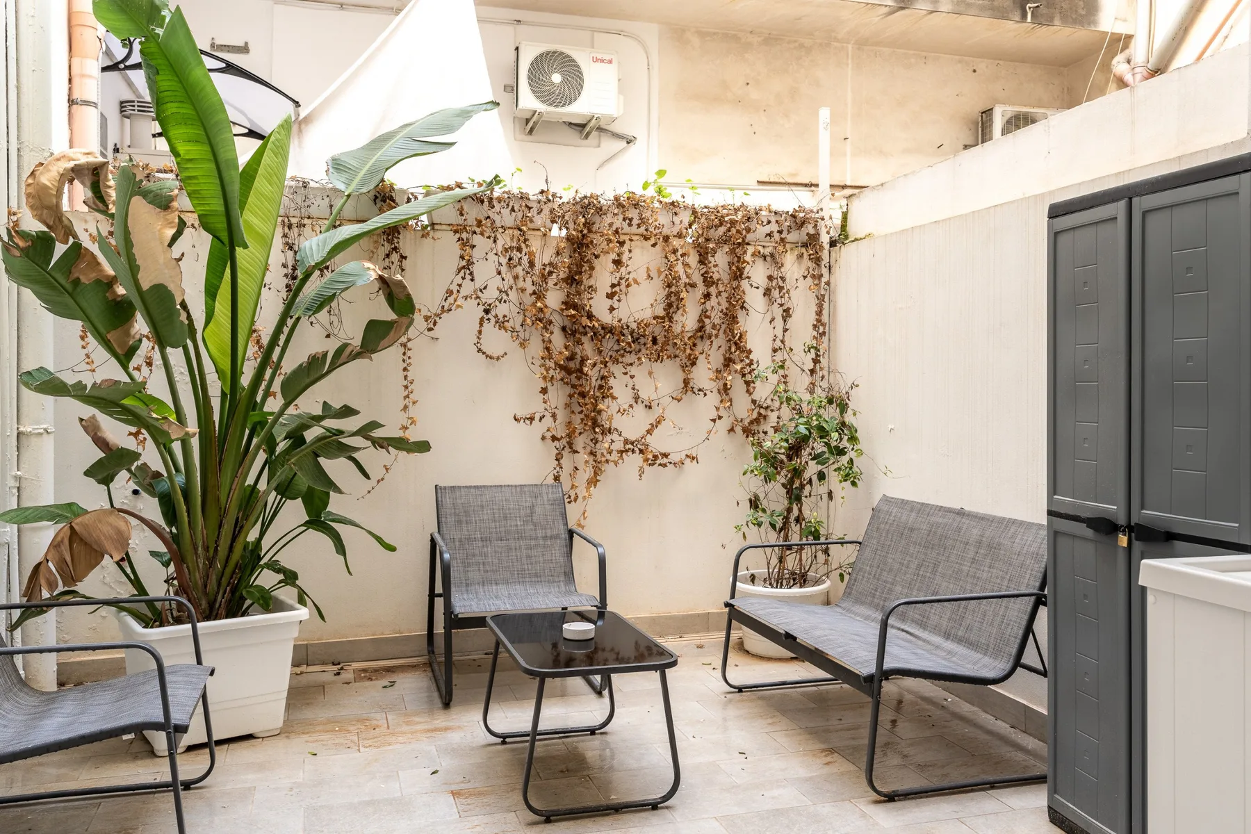 A patio seating area with a low table and potted plants.