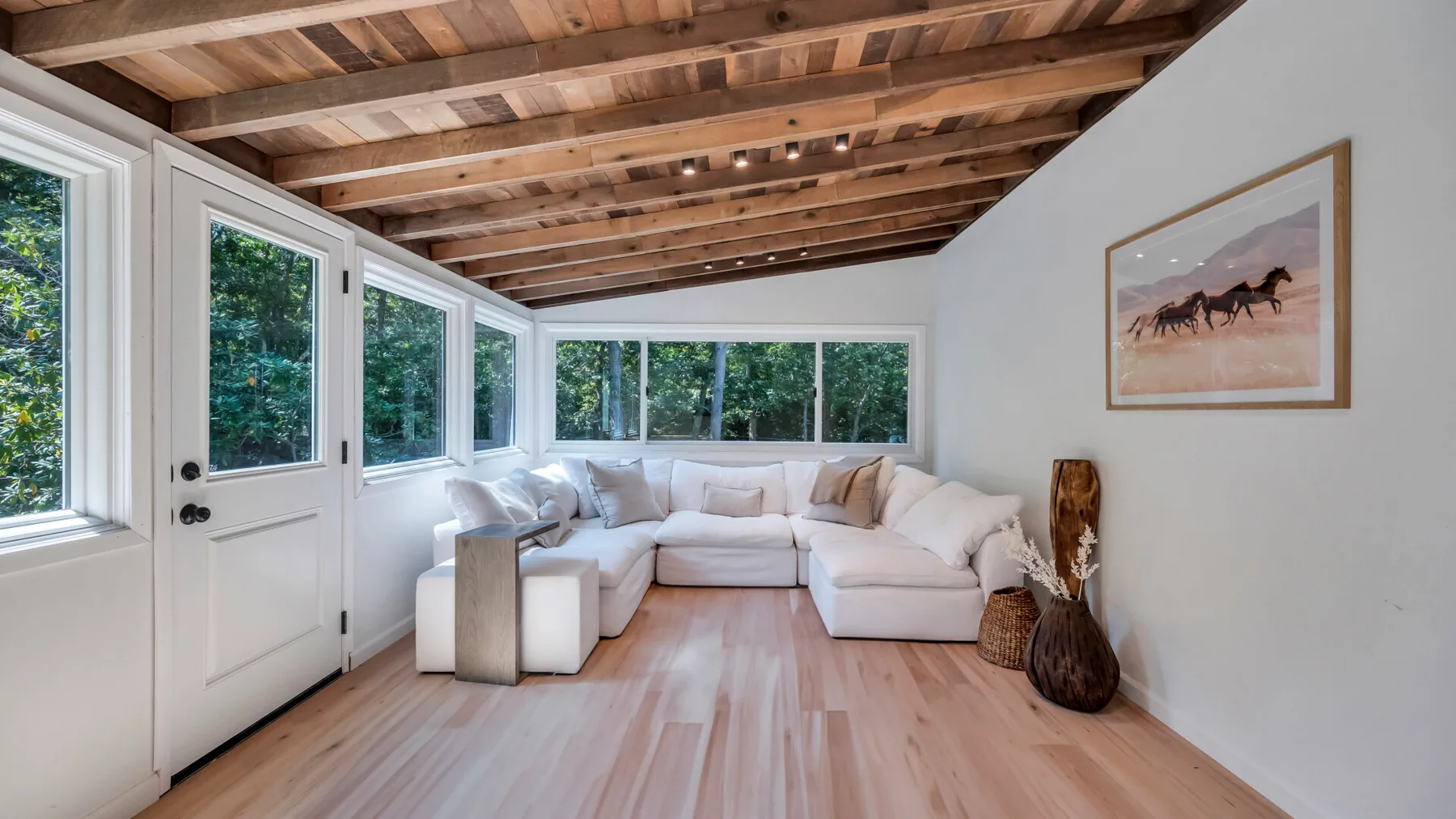 A bright living room with a sectional seating area and large windows.