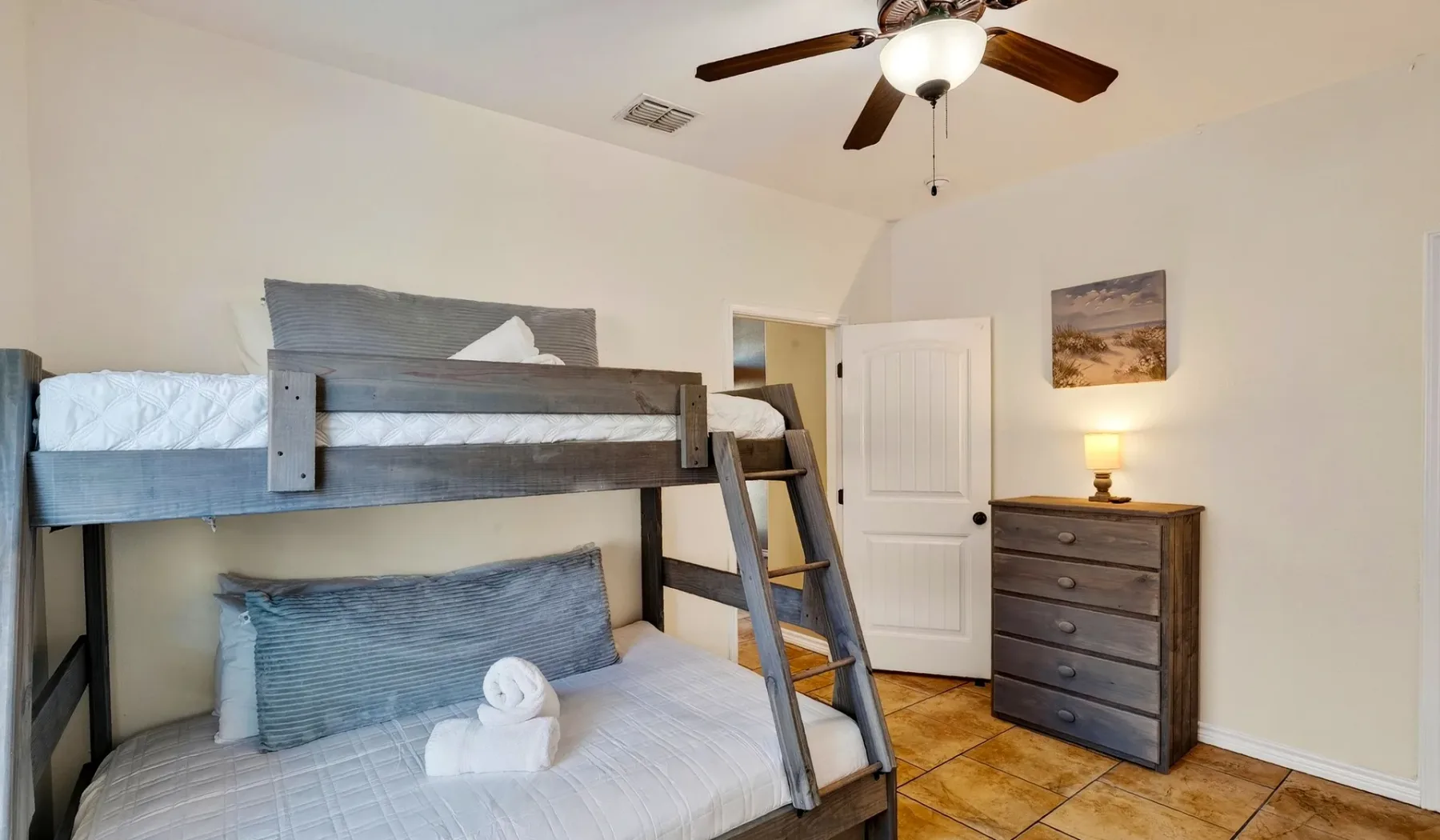 Un dormitorio con una litera de madera y una cómoda.