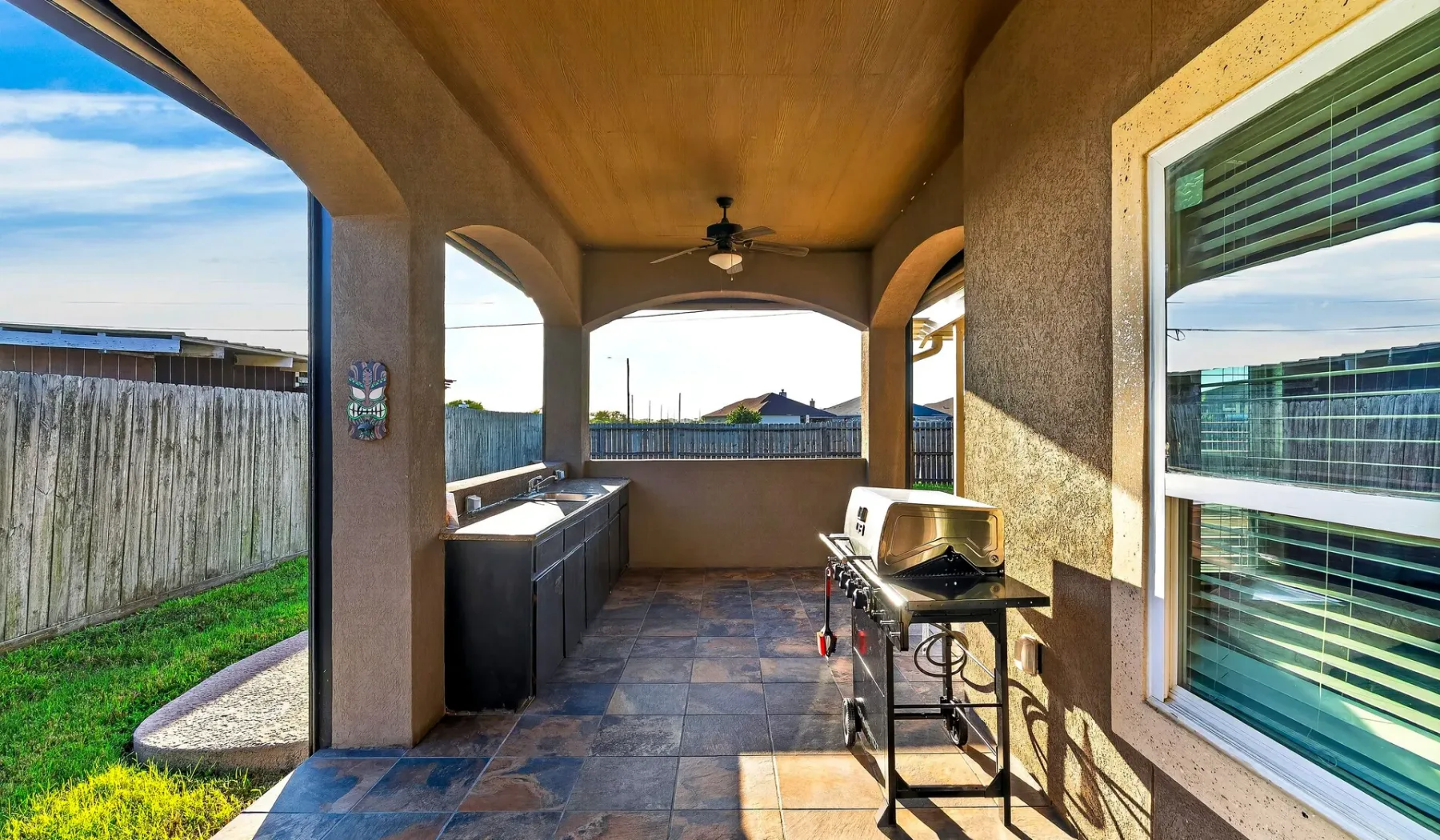 Un patio exterior cubierto con una encimera y una parrilla.