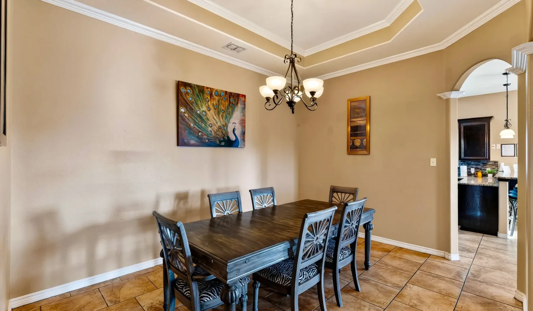 Un comedor con una mesa oscura y arte decorativo en la pared.