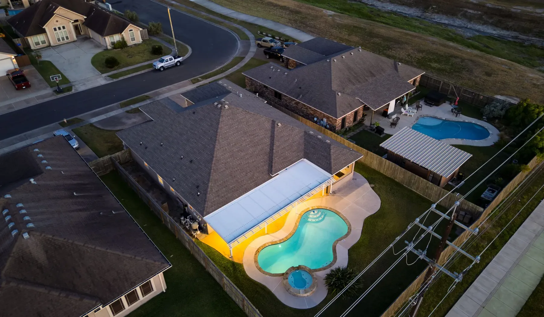Vista aérea de una casa con una piscina curva en el patio trasero.