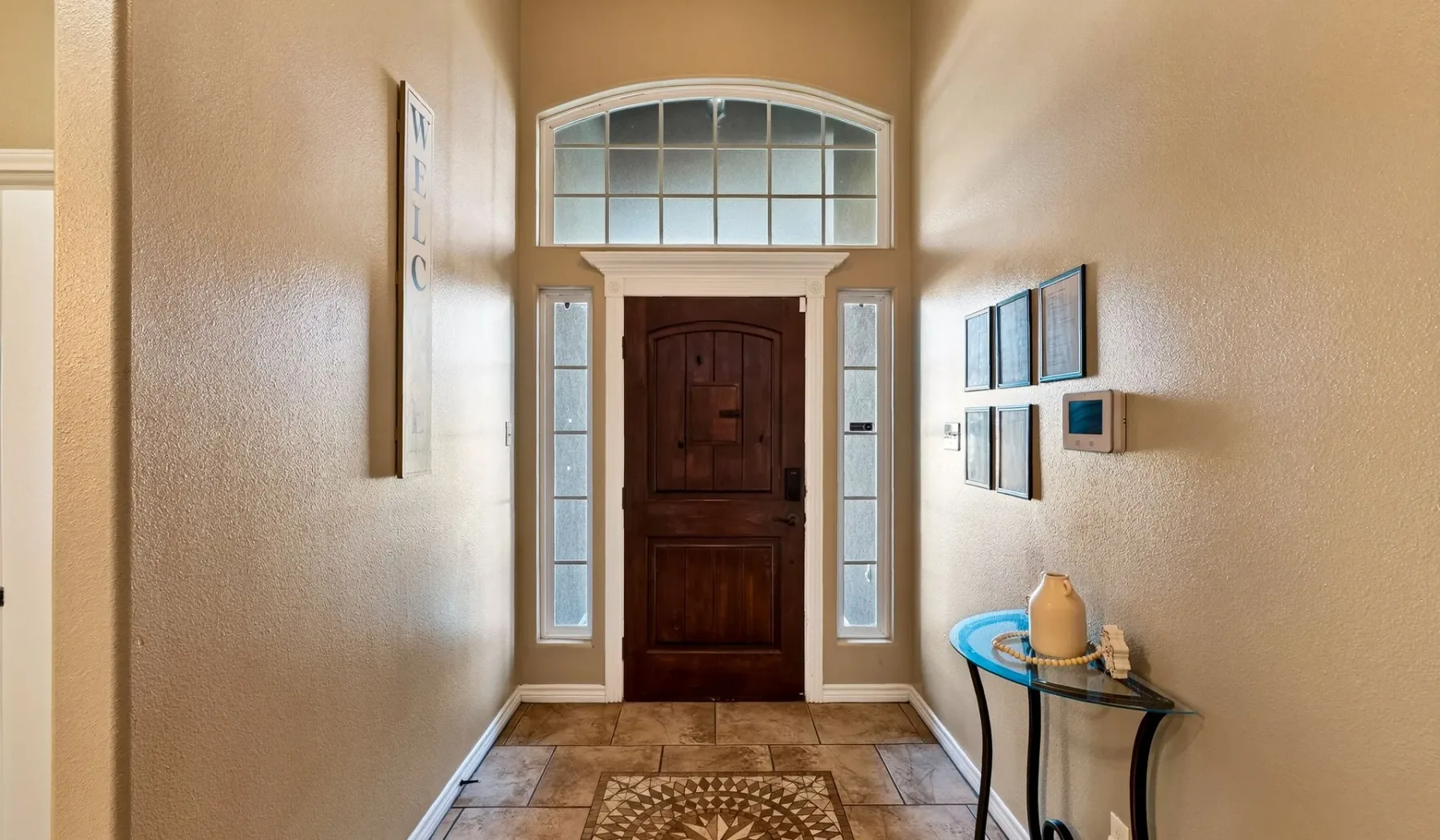 Una entrada con una puerta principal de madera oscura y ventanas arqueadas.