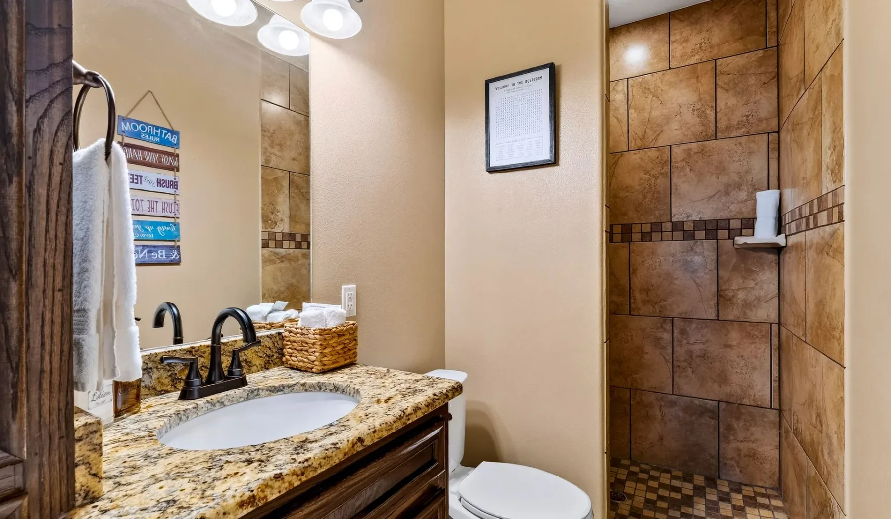 Un tocador de baño con lavabo y una ducha de azulejos.