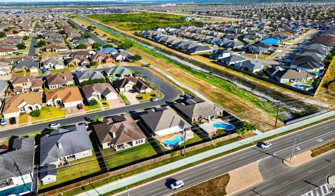 Vista aérea de un barrio residencial con hileras de casas y calles.