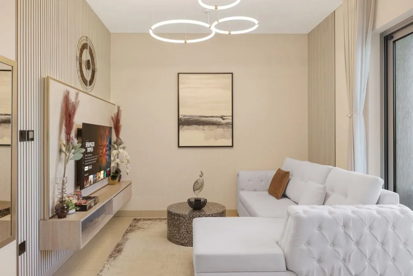 Una sala de estar con asientos blancos, un televisor en la pared y arte enmarcado.