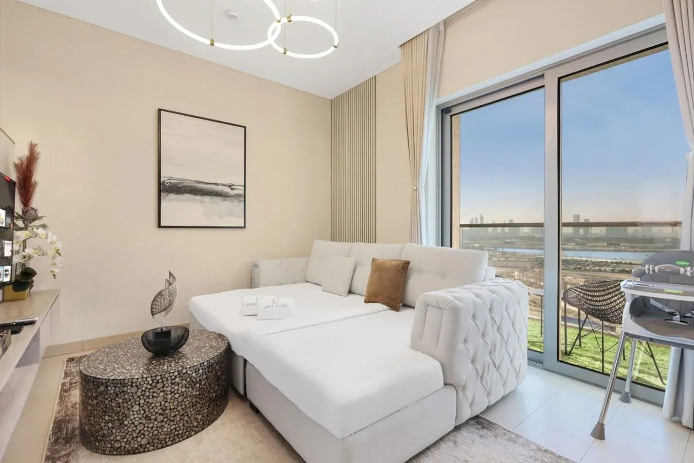 Una sala luminosa con asientos blancos junto a grandes ventanales con vistas a la ciudad.