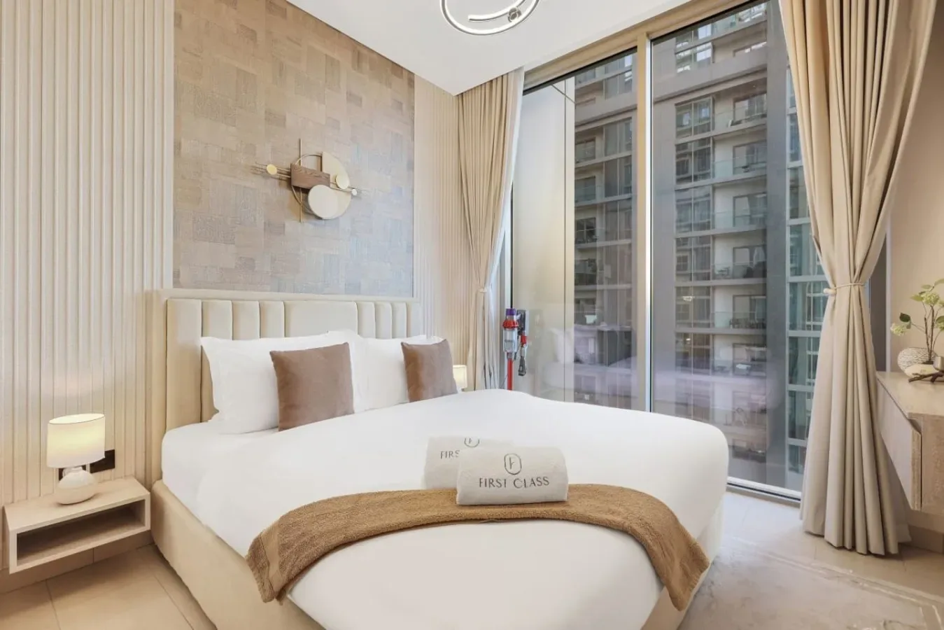 Un dormitorio luminoso con una cama grande junto a ventanas de suelo a techo.