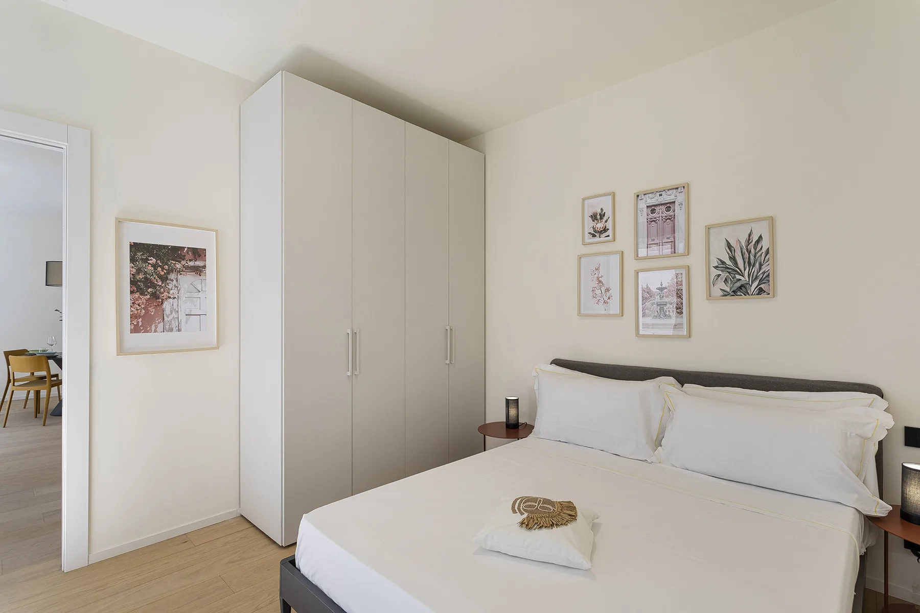 A bright bedroom with a neatly made bed and built-in wardrobes.