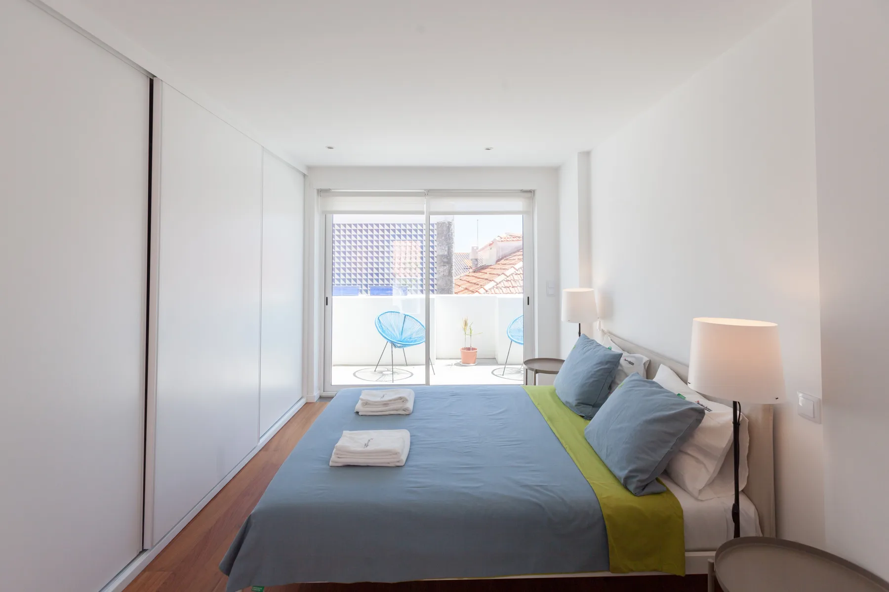 Un dormitorio con una cama y puertas correderas de vidrio que dan a un balcón.