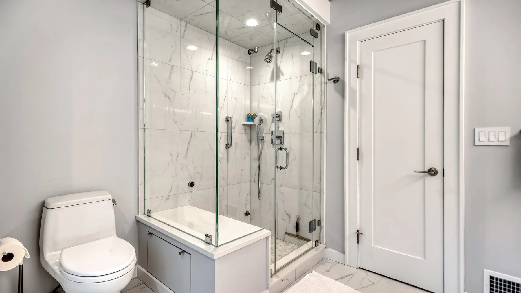 Un baño con ducha de vidrio, bañera e inodoro.