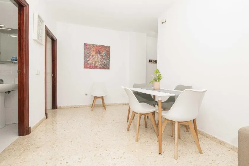 A dining area with a table, chairs, and colorful artwork on the wall.