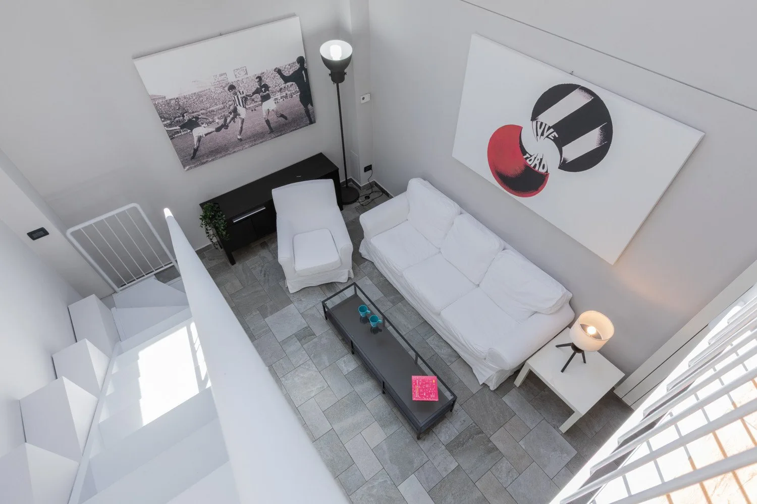Una sala luminosa con asientos blancos y un gran cuadro en la pared.