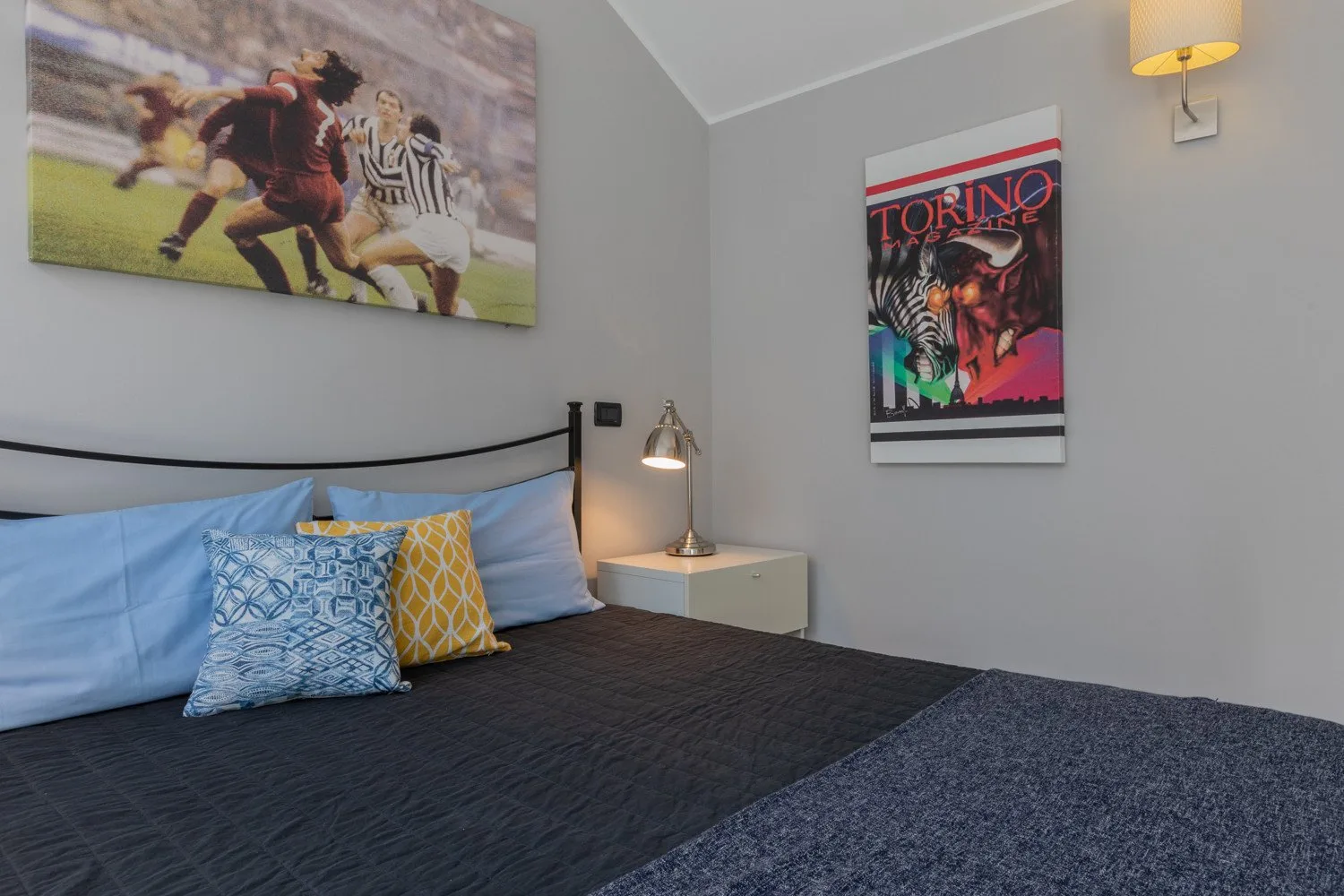 Un dormitorio con una cama tendida y arte deportivo en la pared.