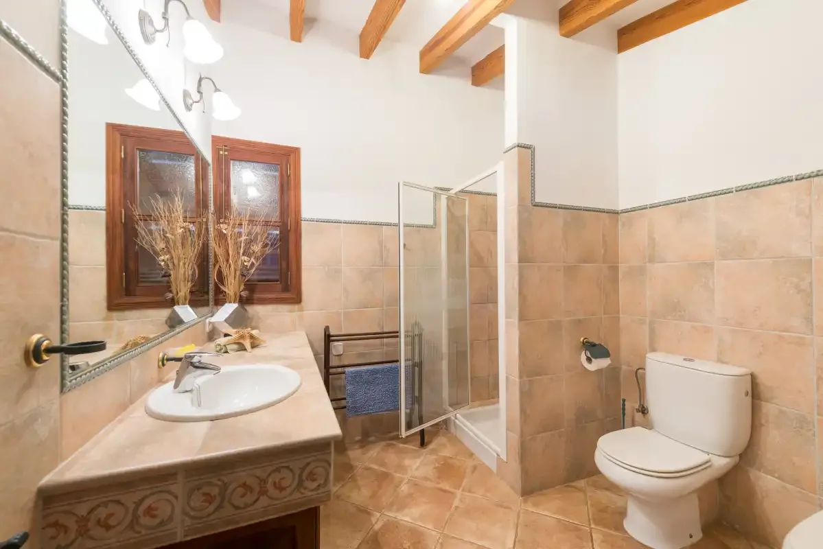 A bathroom with a sink, shower, and toilet.