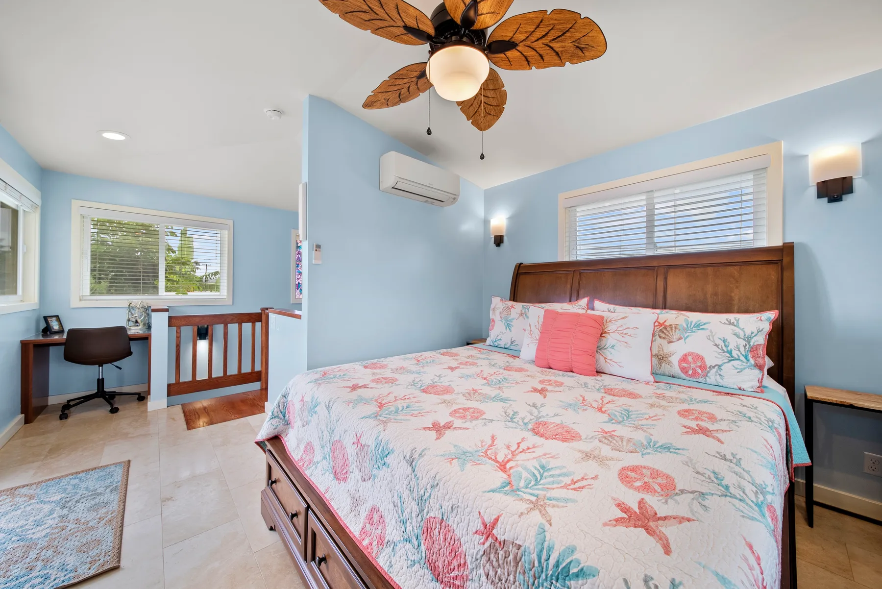 Un dormitorio con una cama grande cubierta con una colcha estampada de colores.