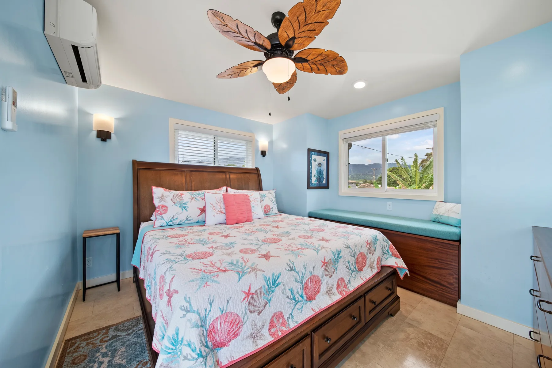 Un dormitorio con cama de madera, ropa de cama colorida y paredes azules.