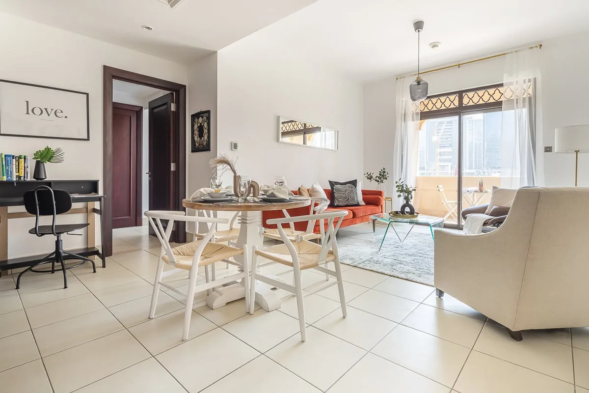 Comedor y sala de estar con una mesa, asientos y ventanas grandes.