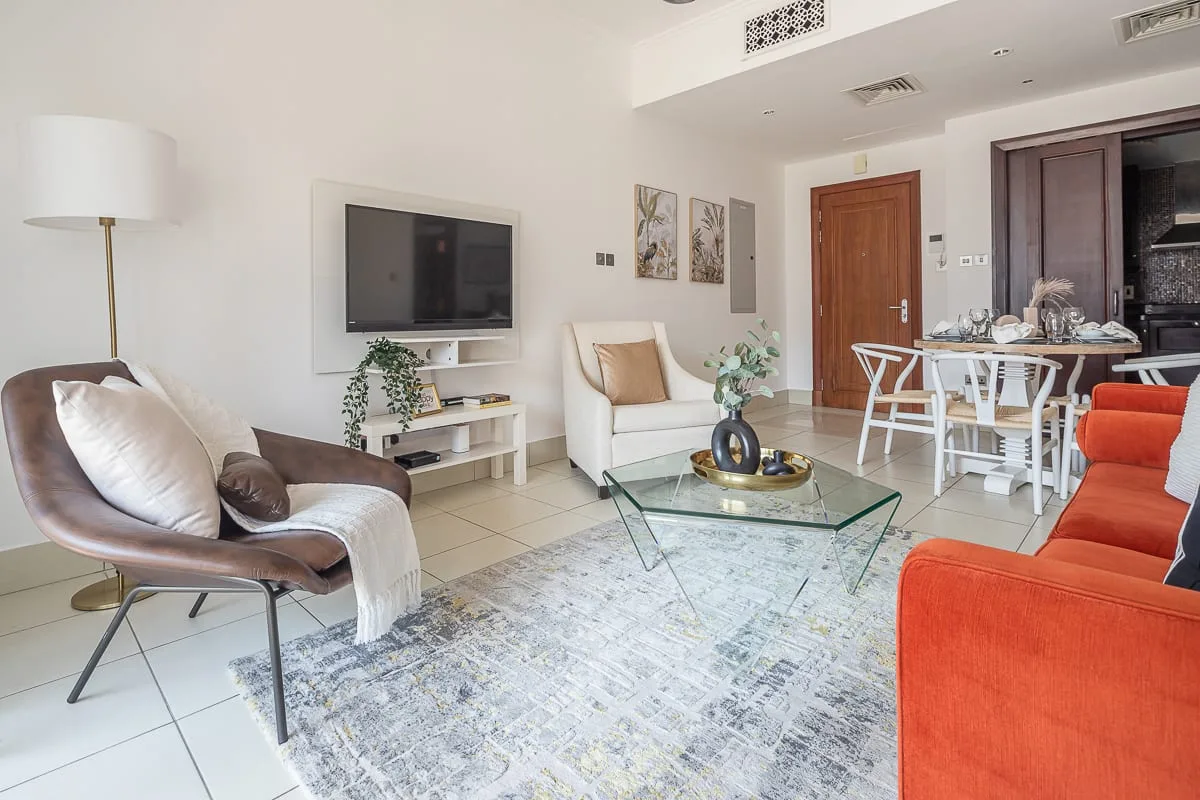 Una luminosa sala de estar y comedor con asientos, un televisor y una mesa de comedor.