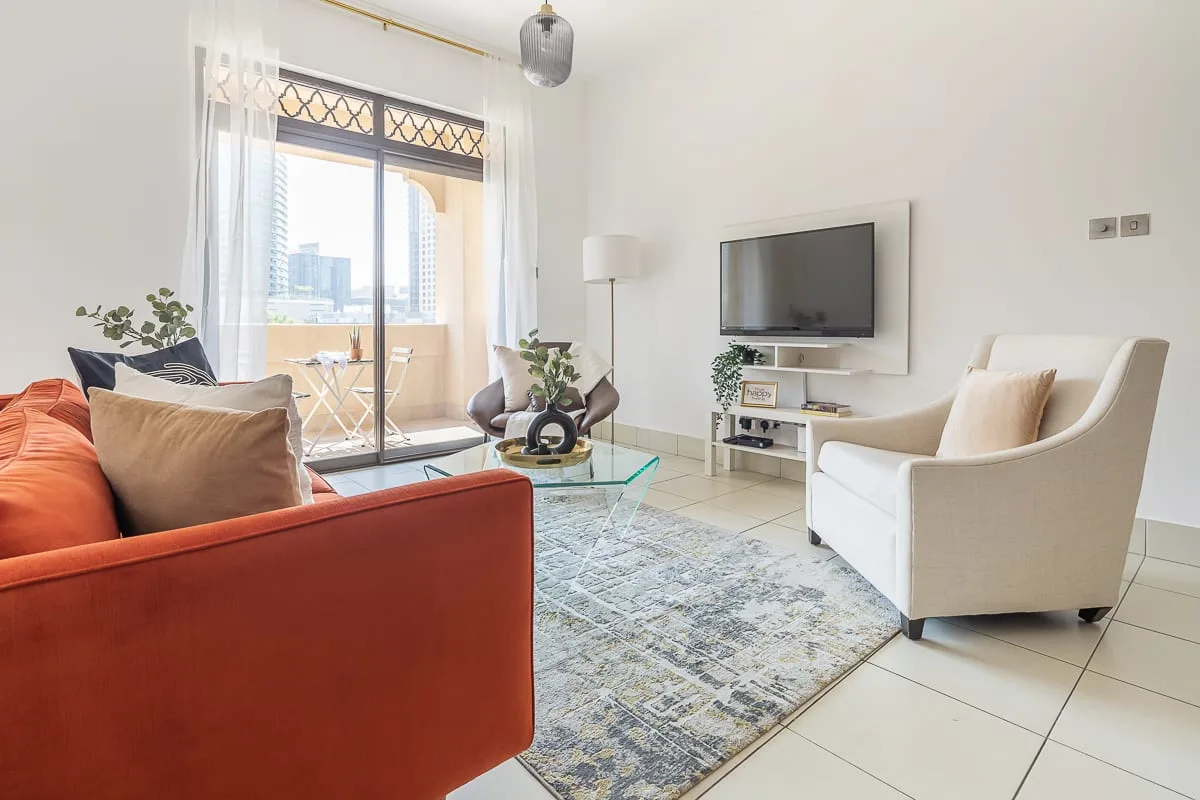 Una sala luminosa con asientos, un televisor y una alfombra.